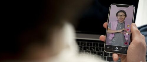 Teenager Watching Video Using His Smartphone While Sitting His Bed